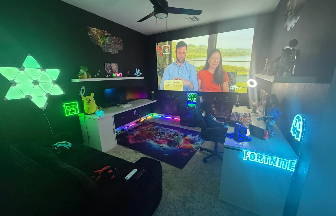 Colorful gaming room with multiple illuminated screens and consoles