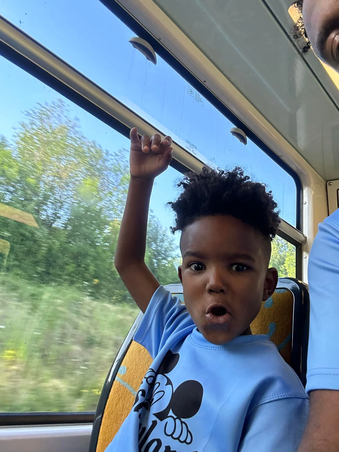 Traveler raising a hand while riding through the countryside